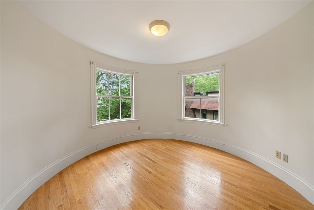 179 Rawson Road, Unit 2 Brookline, MA 02445 - Photo 22 of 42 a view of an empty room with wooden floor and a window