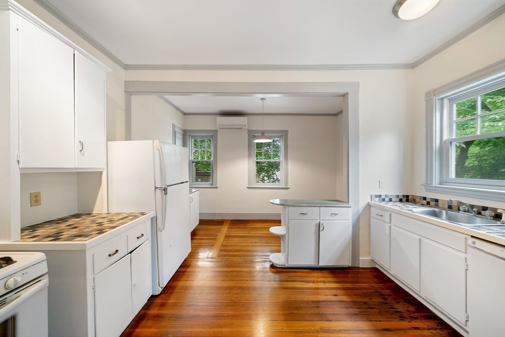 179 Rawson Road, Unit 2 Brookline, MA 02445 - Photo 24 of 42 a kitchen with a sink stove and white cabinets