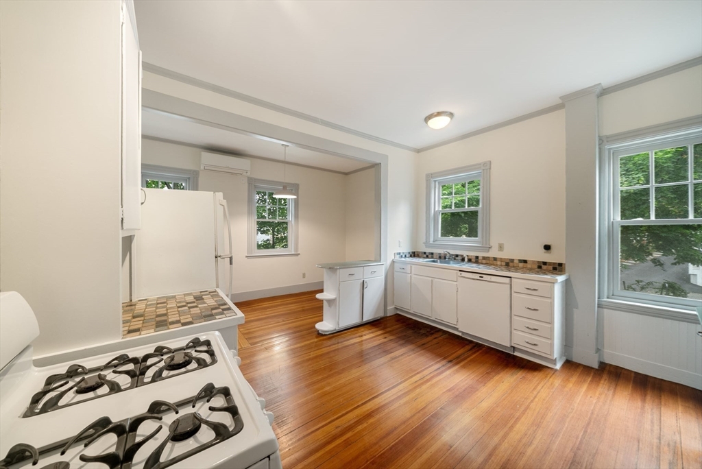 179 Rawson Road, Unit 2 Brookline, MA 02445 - Photo 26 of 42 a kitchen with a wooden floor and white appliances