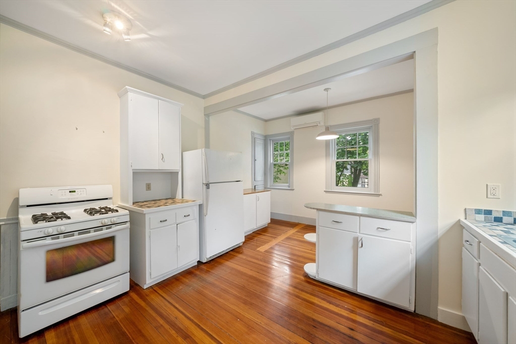 179 Rawson Road, Unit 2 Brookline, MA 02445 - Photo 27 of 42 a kitchen with white cabinets and wooden floor