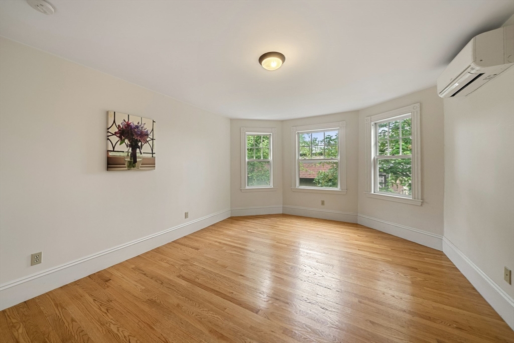 179 Rawson Road, Unit 2 Brookline, MA 02445 - Photo 31 of 42 an empty room with wooden floor and windows