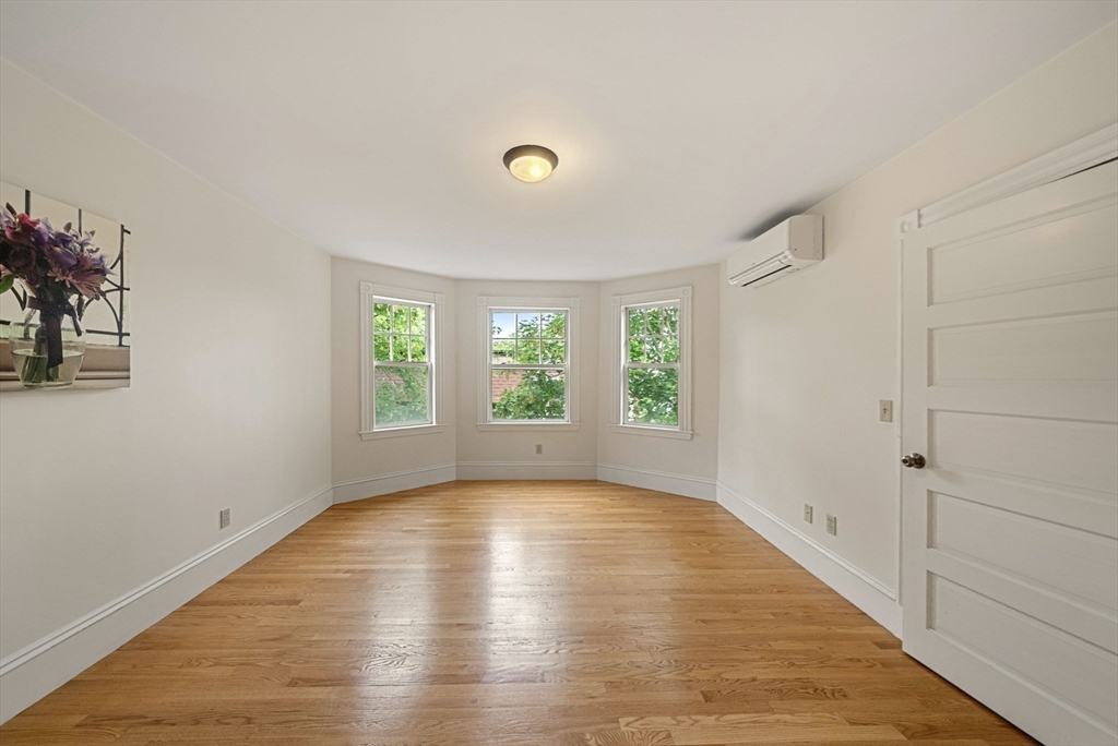 179 Rawson Road, Unit 2 Brookline, MA 02445 - Photo 32 of 42 a view of an empty room with a window and wooden floor