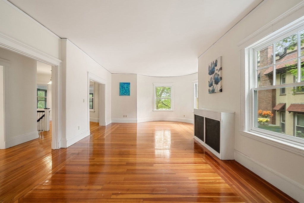 179 Rawson Road, Unit 2 Brookline, MA 02445 - Photo 4 of 42 a view of empty room with wooden floor and fireplace