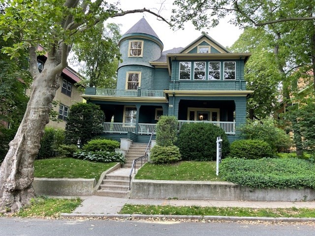 179 Rawson Road, Unit 2 Brookline, MA 02445 - Photo 42 of 42 a view of a brick house with a small yard plants and large tree