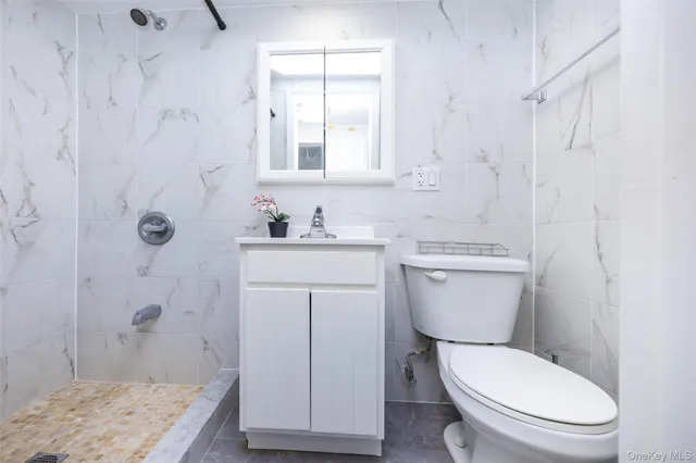 a white toilet sitting next to a bathroom sink