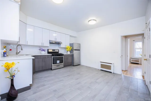 a kitchen with granite countertop a sink cabinets and stainless steel appliances