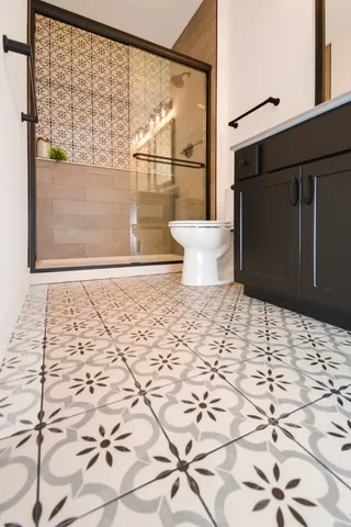 a bathroom with a sink a toilet a mirror and shower