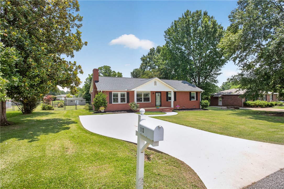 113 Greenfield Avenue Pendleton, SC 29670 - Photo 2 of 40 A classic brick ranch home with a broad, curving driveway and welcoming front porch.