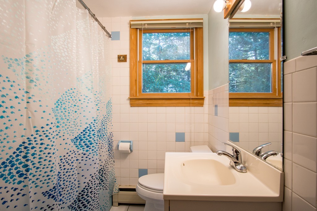 22 Leigh Road Wenham, MA 01984 - Photo 10 of 28 a bathroom with a sink a toilet and a mirror