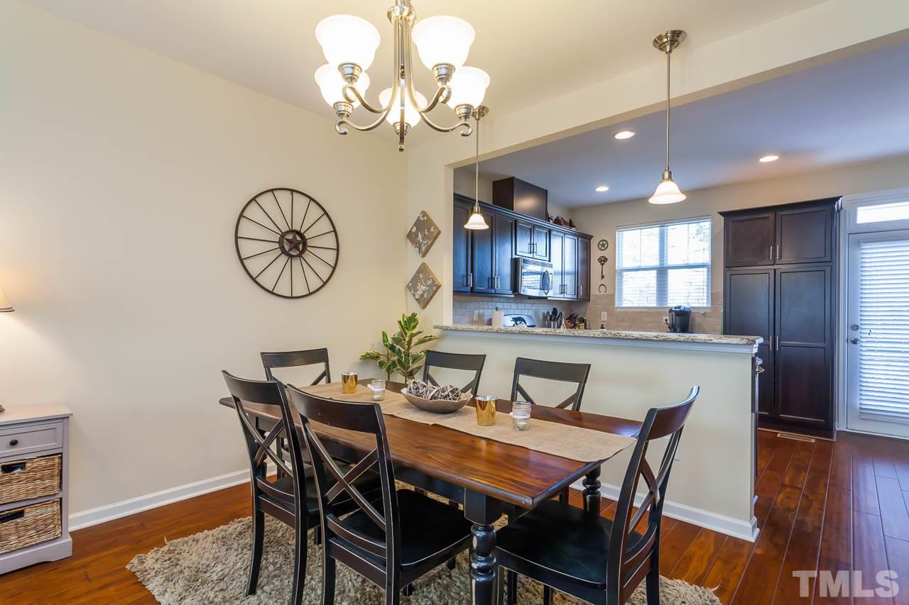 1651 Crafton Way Raleigh, NC 27607 - Photo 7 of 20 a view of a dining room with furniture a chandelier and wooden floor