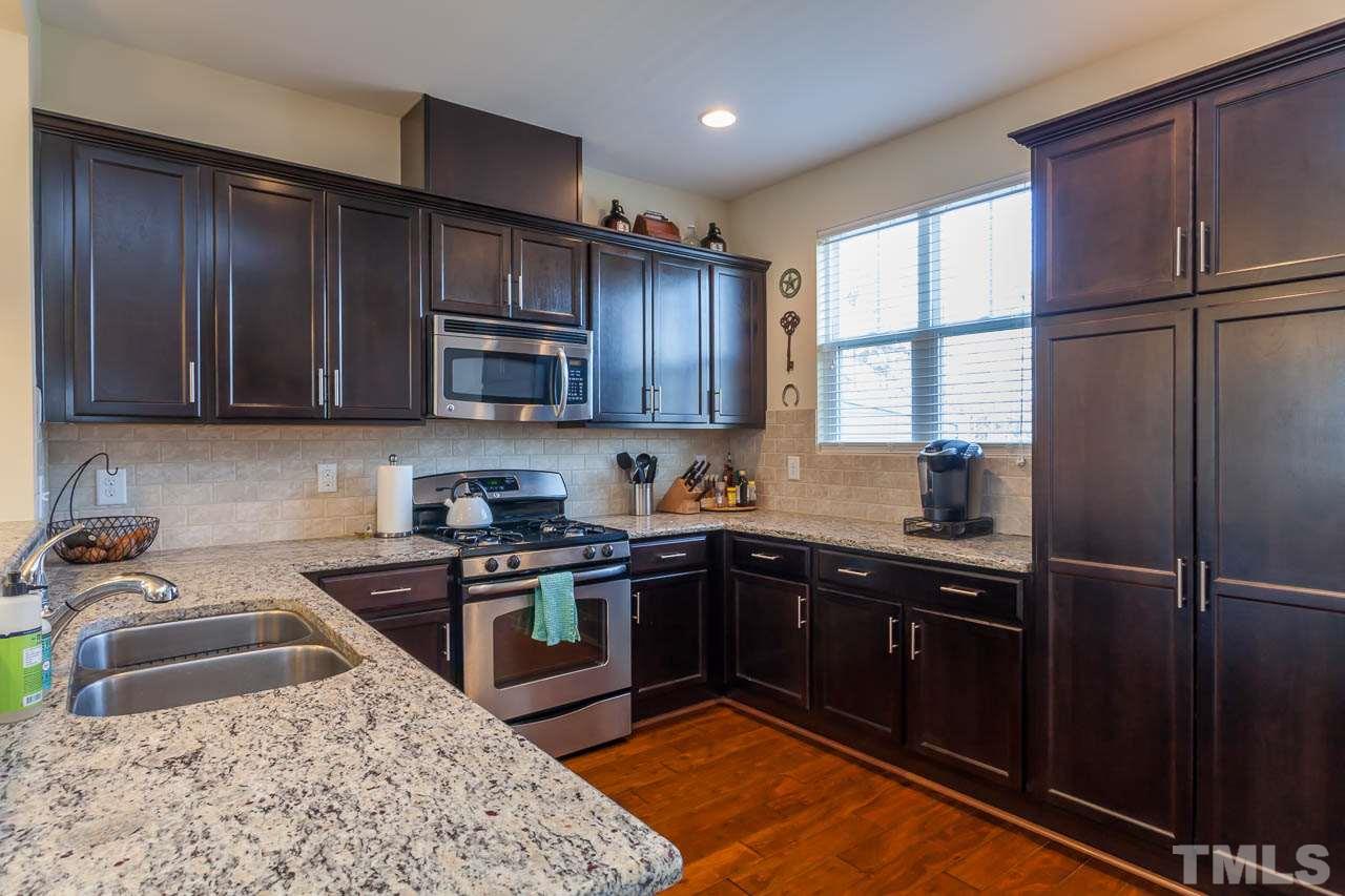 1651 Crafton Way Raleigh, NC 27607 - Photo 8 of 20 a kitchen with stainless steel appliances granite countertop a stove a sink dishwasher a refrigerator and cabinets with wooden floor