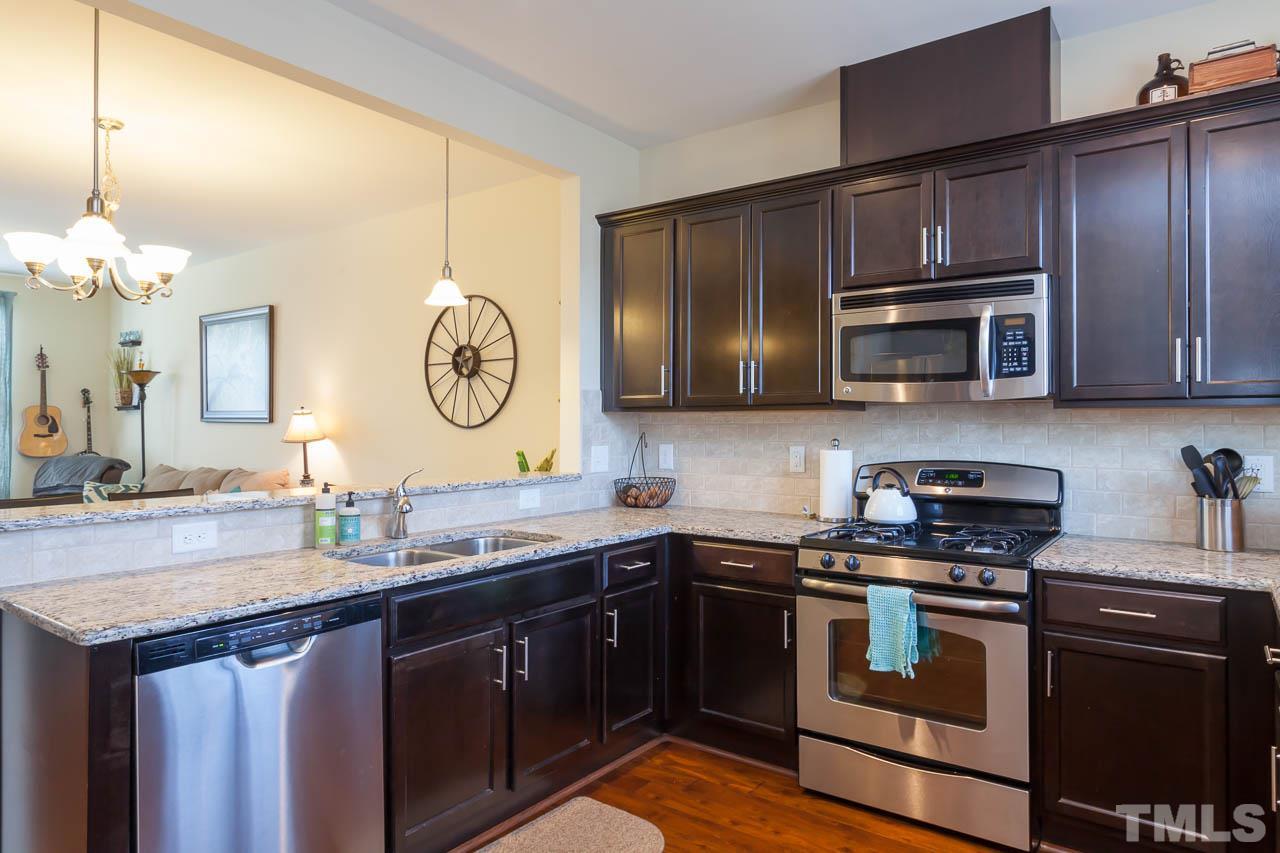1651 Crafton Way Raleigh, NC 27607 - Photo 9 of 20 a kitchen with stainless steel appliances granite countertop a stove a sink and a microwave