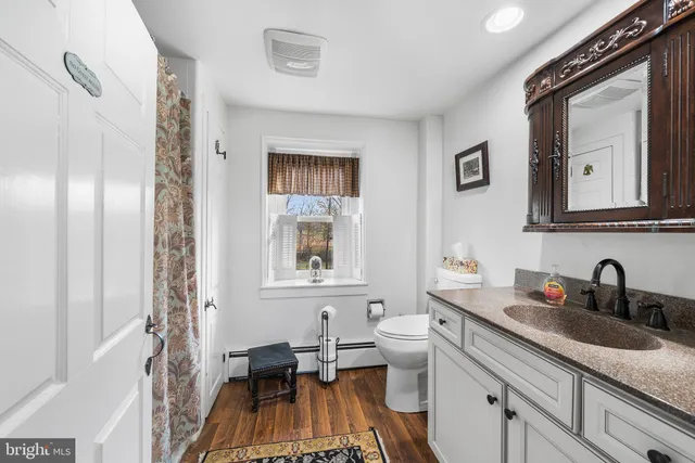 a en suite bathroom with a granite countertop sink and a mirror