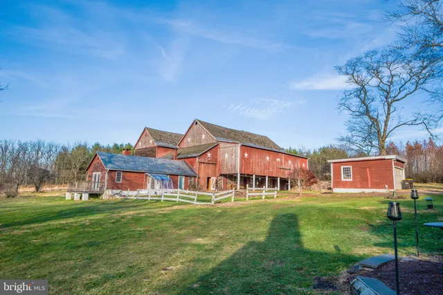 a view of a big house with a big yard and large trees