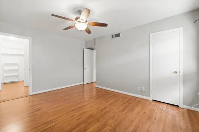 a view of an empty room with wooden floor