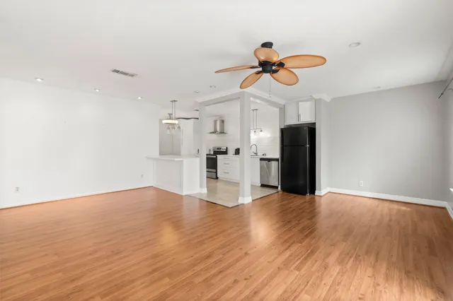 a view of a kitchen with wooden floor and a ceiling fan