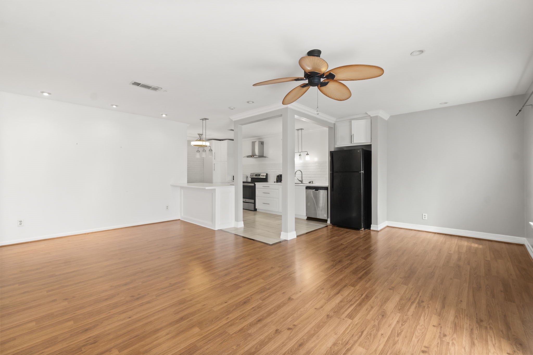 2824 Briarhurst Drive, Unit 14 Houston, TX 77057 - Photo 7 of 26 a view of a kitchen with wooden floor and a ceiling fan
