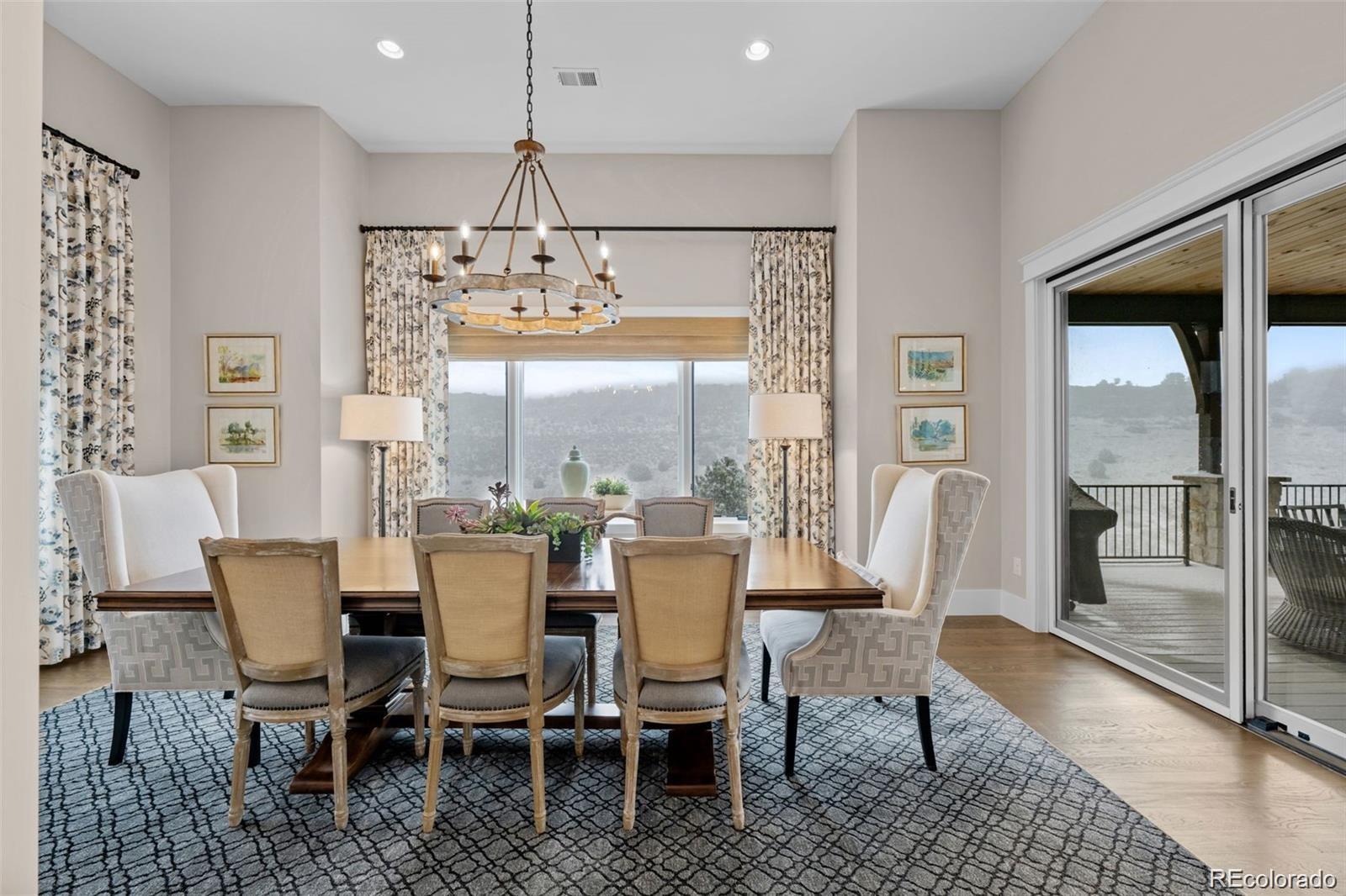 7912 Raphael Lane Littleton, CO 80125 - Photo 17 of 50 a dining room with furniture a chandelier and wooden floor