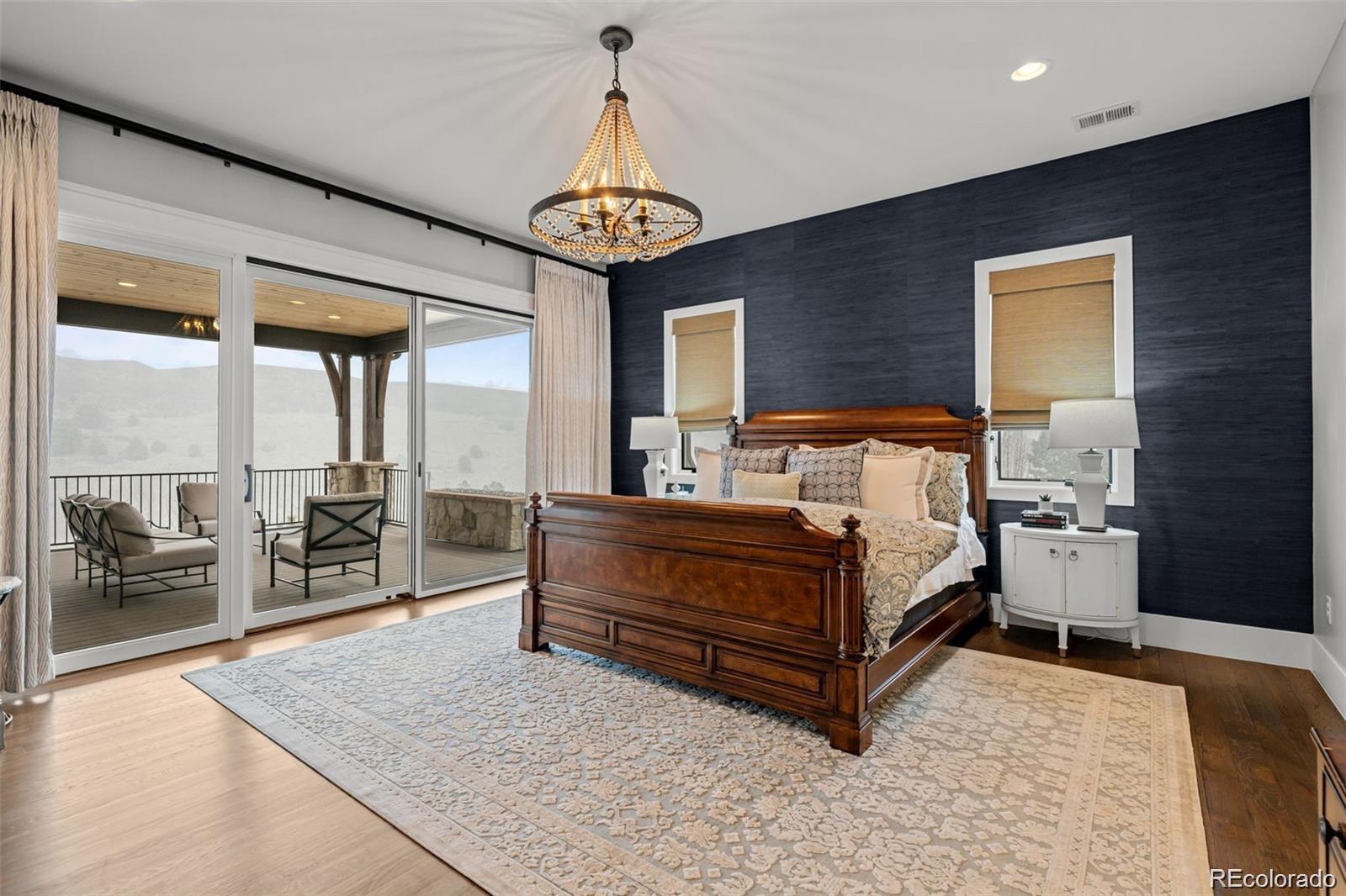 7912 Raphael Lane Littleton, CO 80125 - Photo 20 of 50 a bed room with a bed and a chandelier