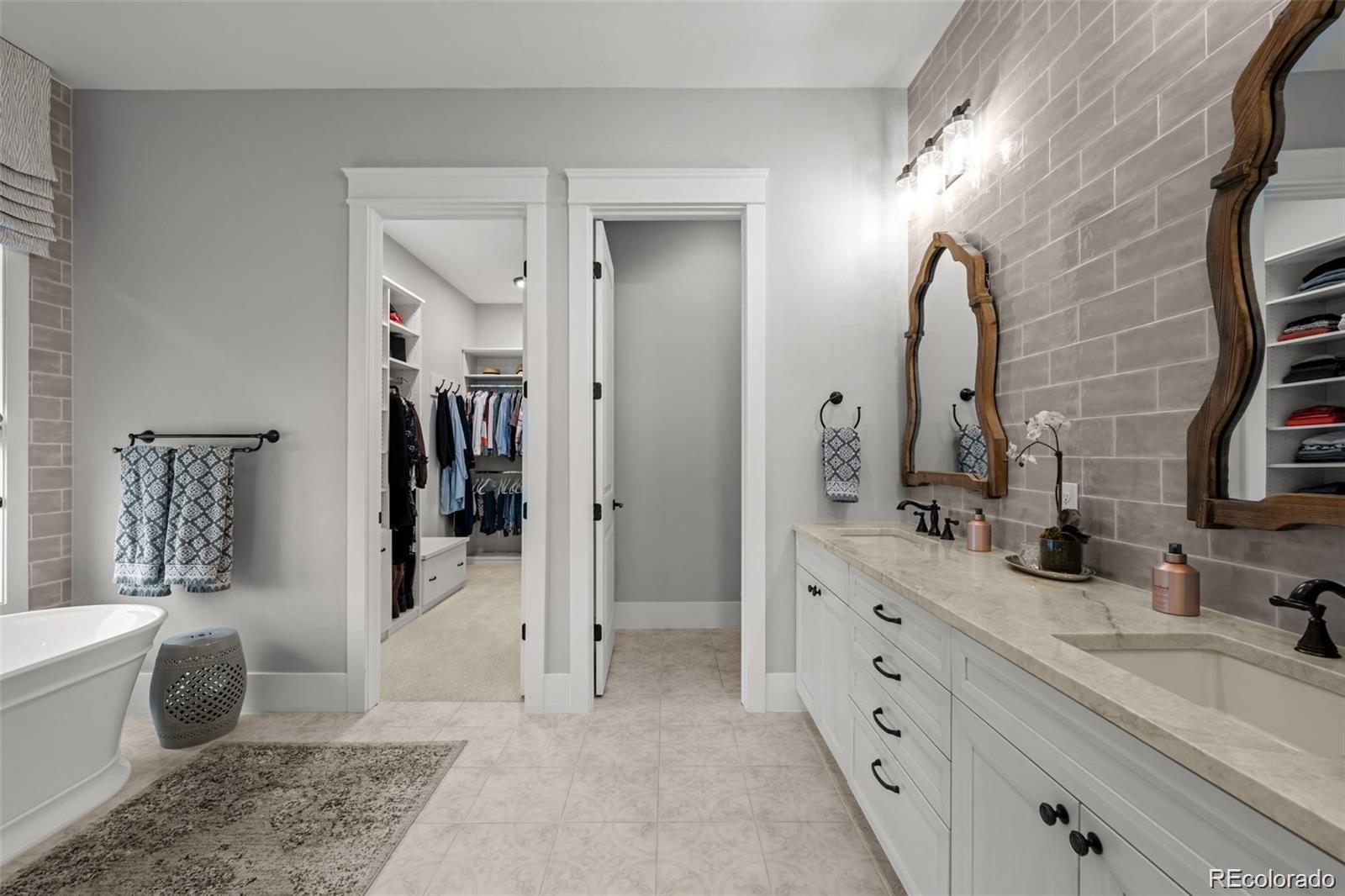 7912 Raphael Lane Littleton, CO 80125 - Photo 22 of 50 a spacious bathroom with double vanity a toilet a and a mirror