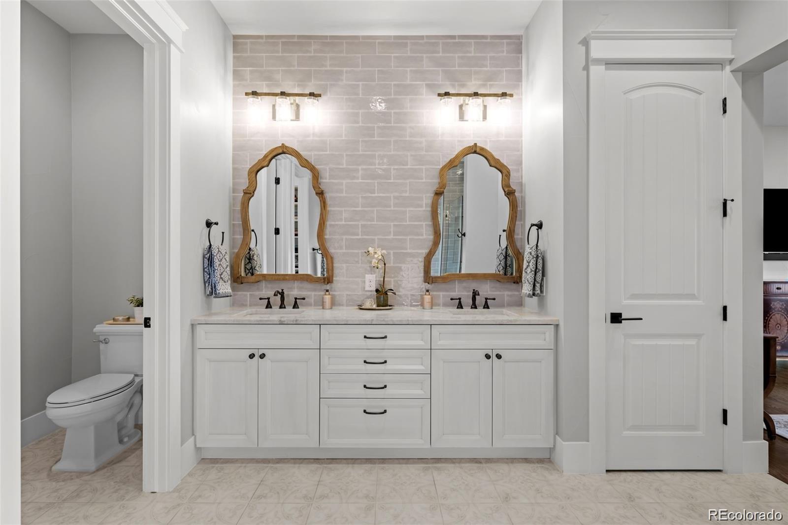 7912 Raphael Lane Littleton, CO 80125 - Photo 23 of 50 a bathroom with a double vanity sink and a toilet