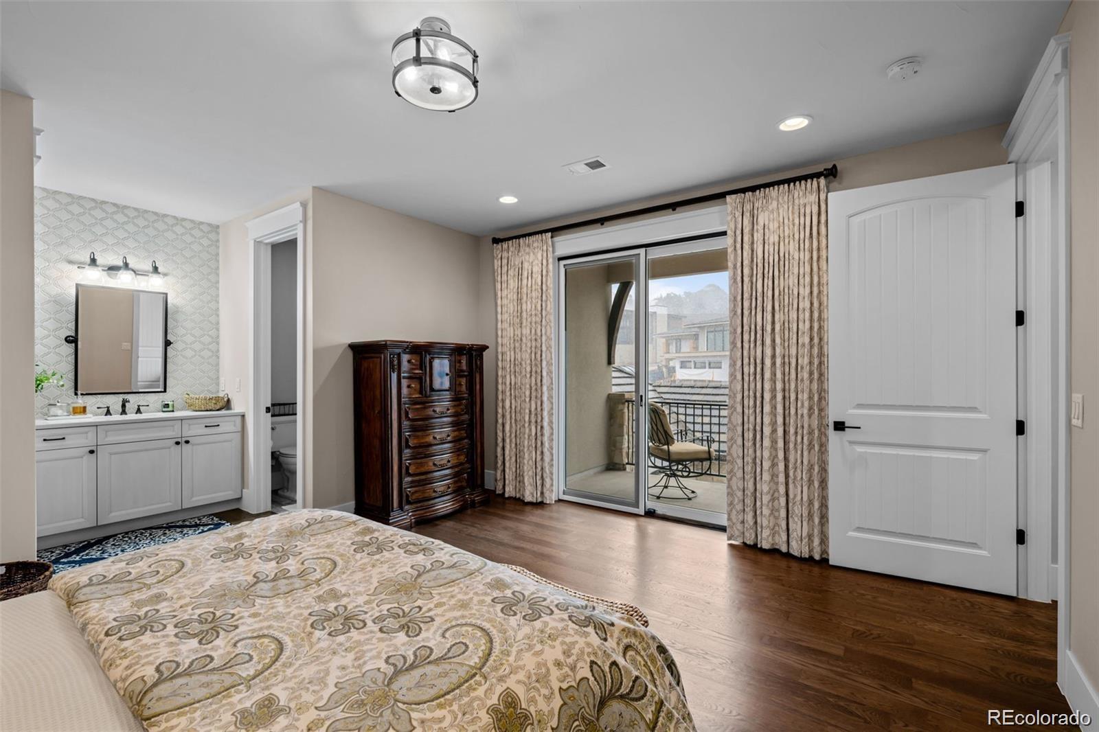 7912 Raphael Lane Littleton, CO 80125 - Photo 29 of 50 a large bedroom with a bed and wooden floor