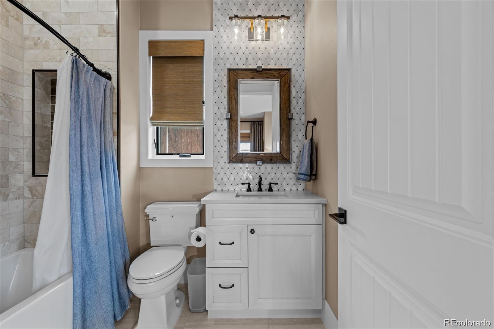 7912 Raphael Lane Littleton, CO 80125 - Photo 39 of 50 a bathroom with a toilet sink and mirror