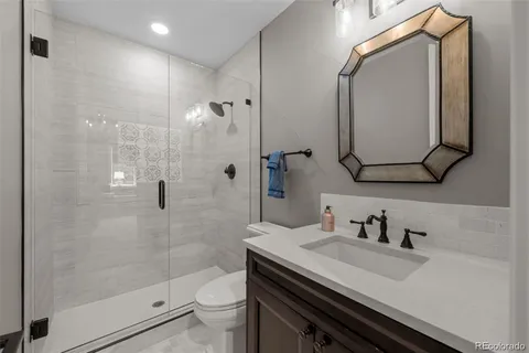 a bathroom with a granite countertop sink toilet and shower