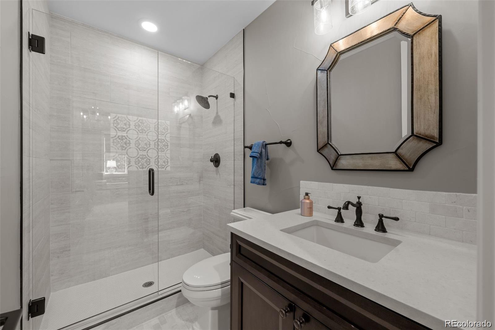 7912 Raphael Lane Littleton, CO 80125 - Photo 41 of 50 a bathroom with a granite countertop sink toilet and shower