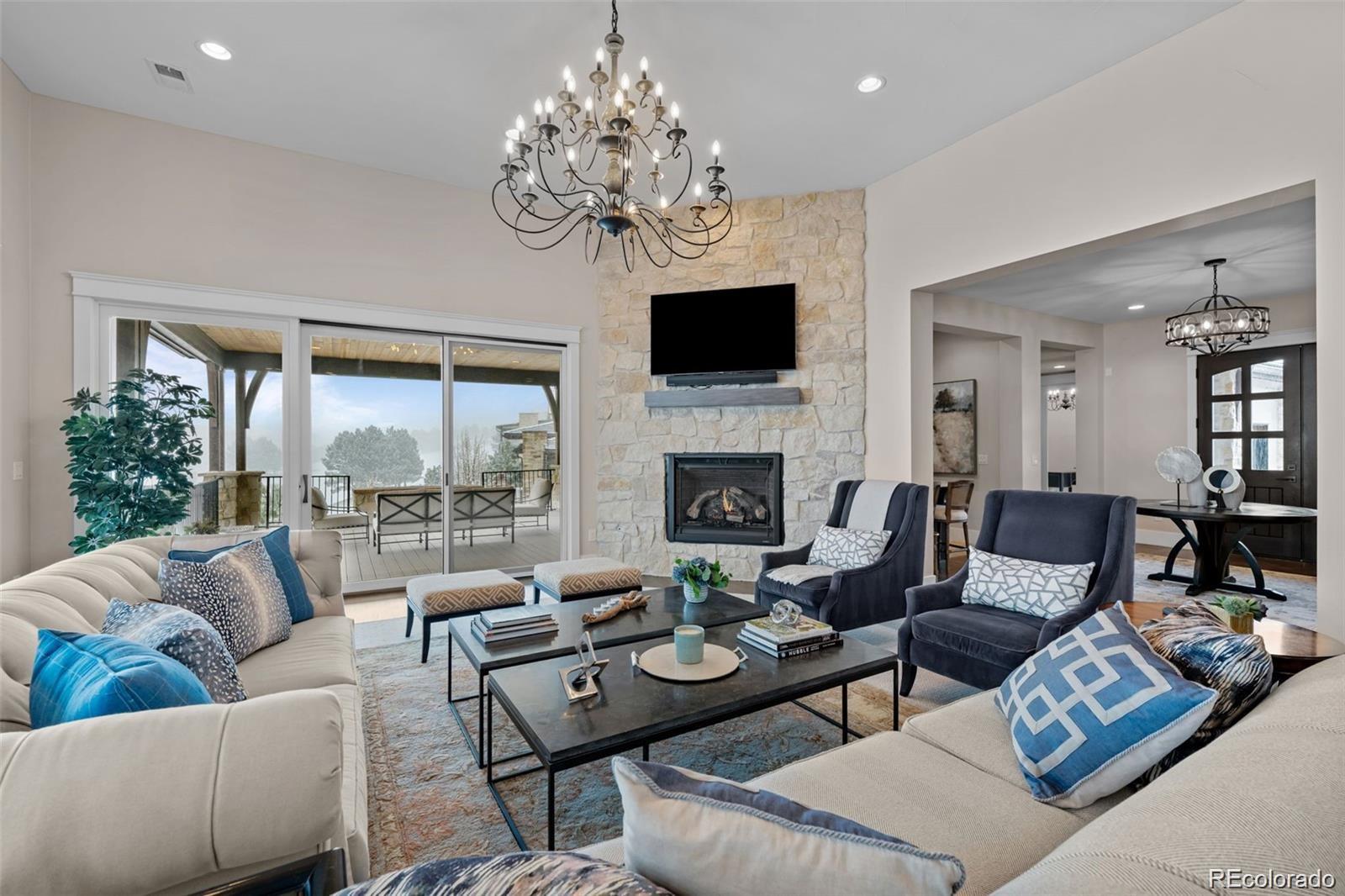 7912 Raphael Lane Littleton, CO 80125 - Photo 10 of 50 a living room with furniture a chandelier and a flat screen tv
