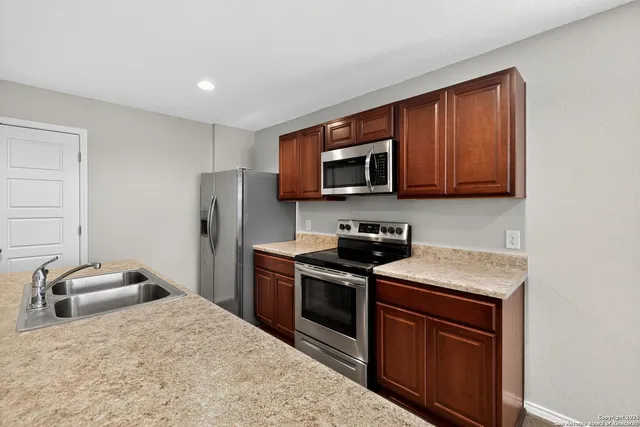 a kitchen with stainless steel appliances granite countertop a stove sink microwave and refrigerator