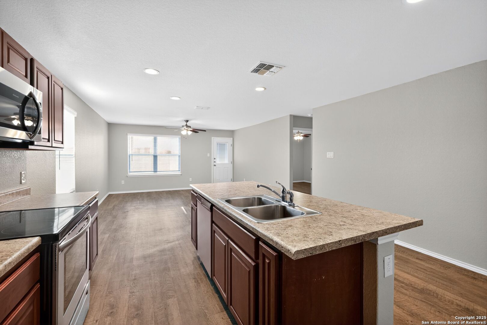 3921 Asher Alley St. Hedwig, TX 78152 - Photo 13 of 30 a kitchen with granite countertop kitchen island a sink stove and wooden floor