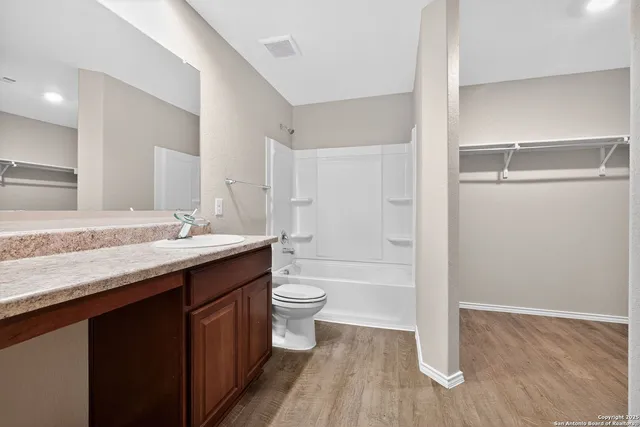 a bathroom with a granite countertop sink toilet a large mirror and shower