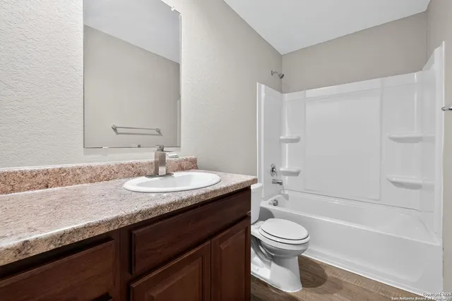 a bathroom with a granite countertop sink toilet a mirror and shower