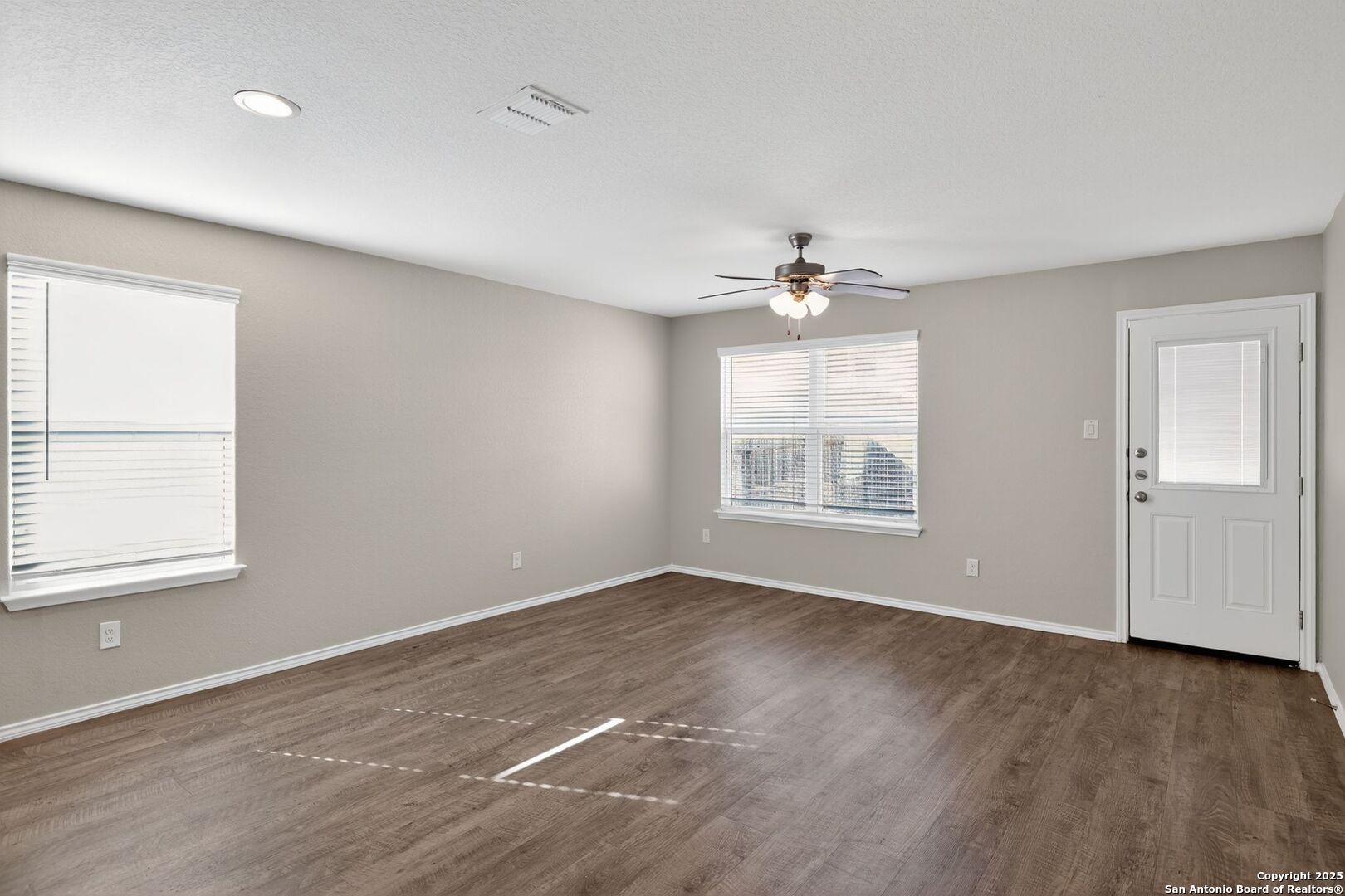 3921 Asher Alley St. Hedwig, TX 78152 - Photo 4 of 30 an empty room with wooden floor chandelier fan and windows