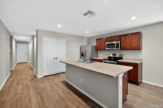 a kitchen with stainless steel appliances a sink stove and refrigerator