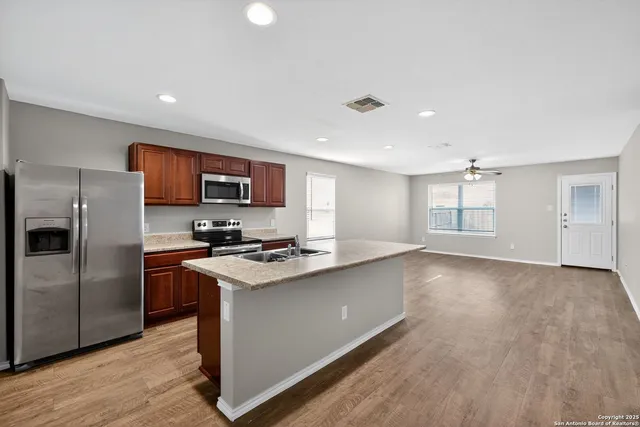 a kitchen with stainless steel appliances a refrigerator sink and microwave
