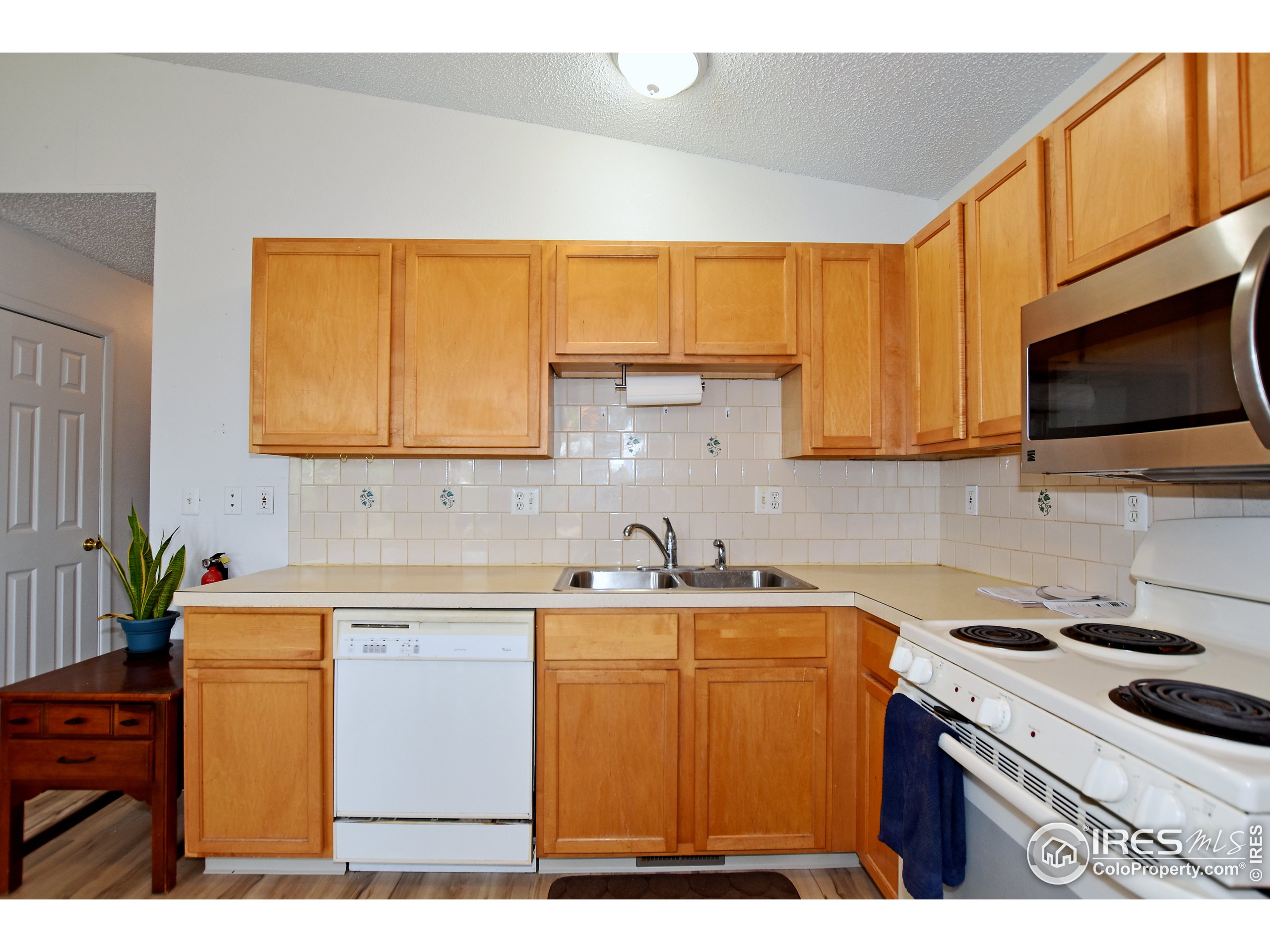 207 Cave Avenue Pierce, CO 80650 - Photo 13 of 35 a kitchen with a sink a stove cabinets and a window