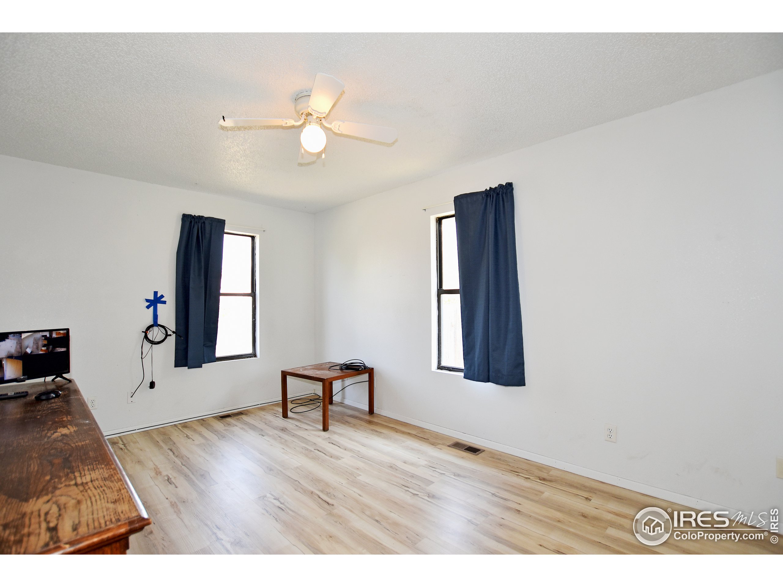 207 Cave Avenue Pierce, CO 80650 - Photo 14 of 35 a view of an empty room with wooden floor and a window