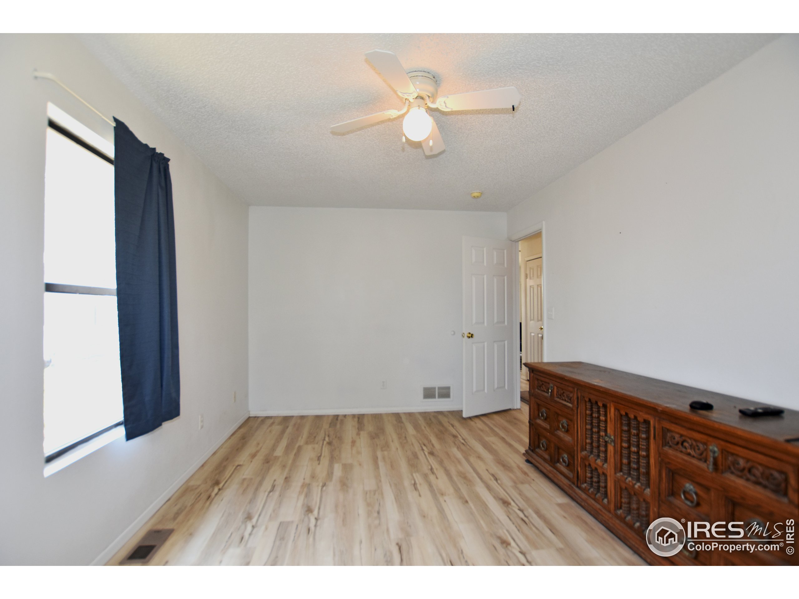 207 Cave Avenue Pierce, CO 80650 - Photo 16 of 35 a view of an empty room with wooden floor