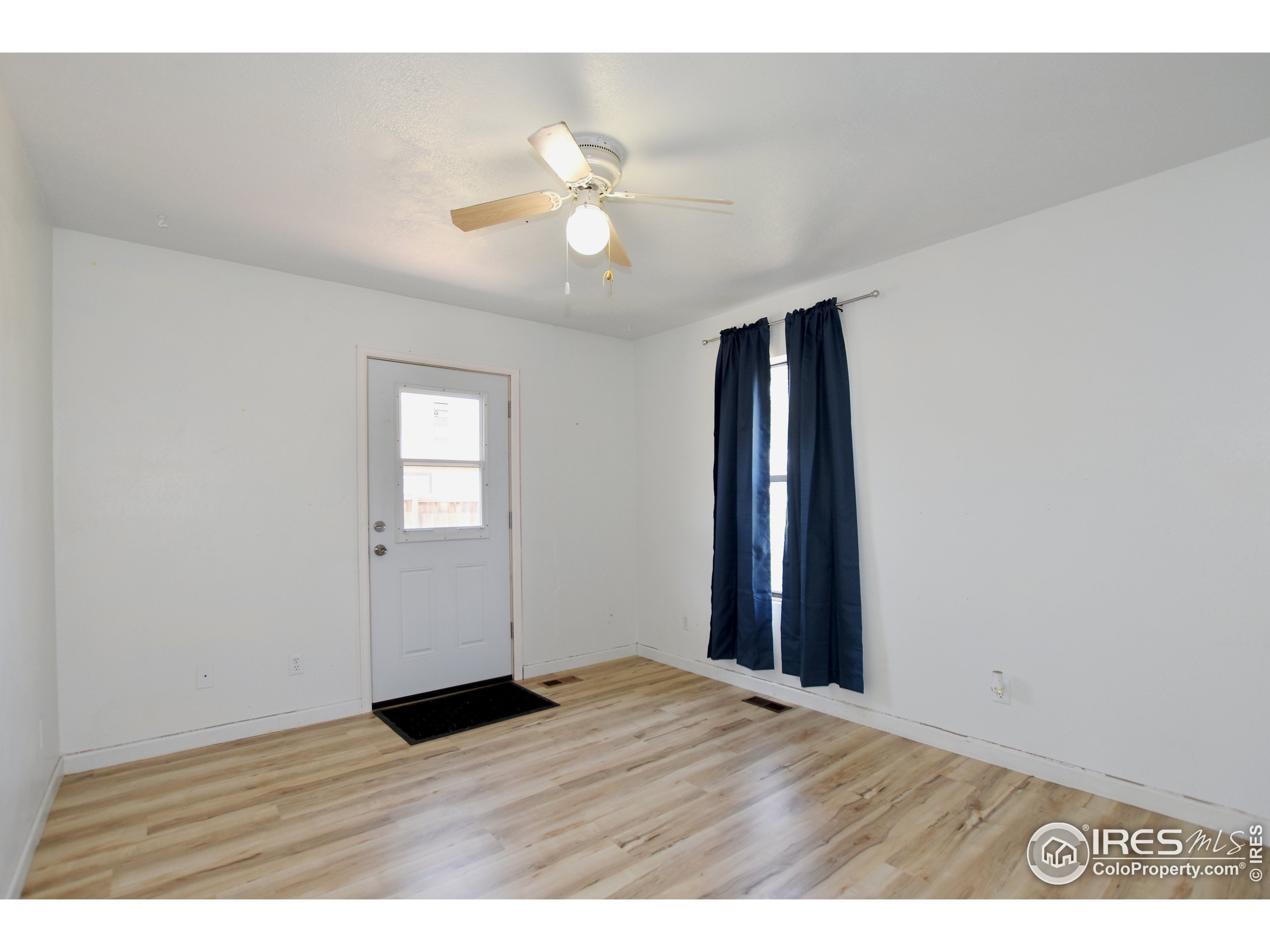207 Cave Avenue Pierce, CO 80650 - Photo 19 of 35 a view of an empty room with wooden floor and fan