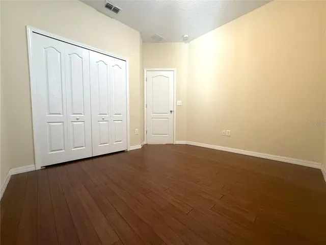 a view of an empty room with wooden floor