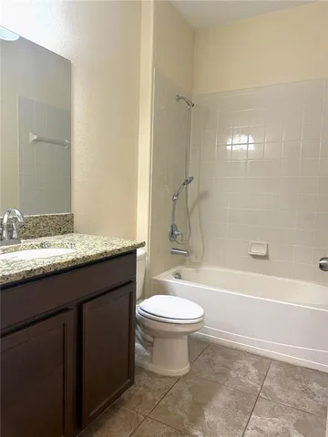 a bathroom with a granite countertop toilet a sink and a bathtub