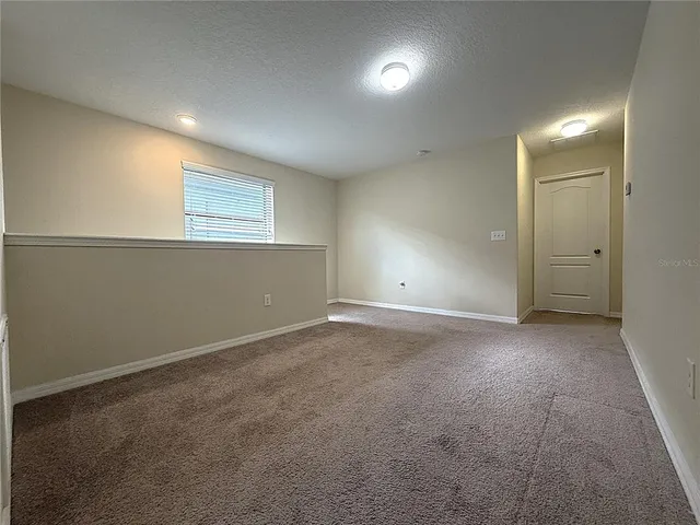 an empty room with windows and entrance to other room