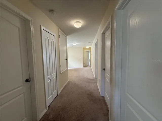 a view of a hallway with a livingroom and a bathroom