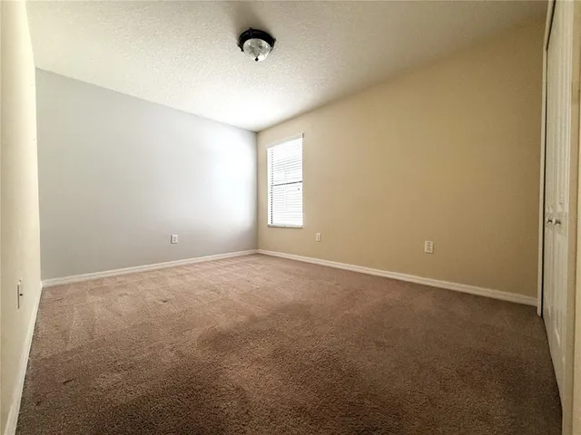 an empty room with windows and closet