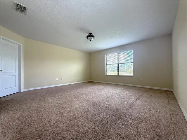 a view of a big room with windows and chandelier fan