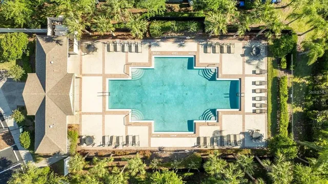 an aerial view of residential houses with outdoor space and trees
