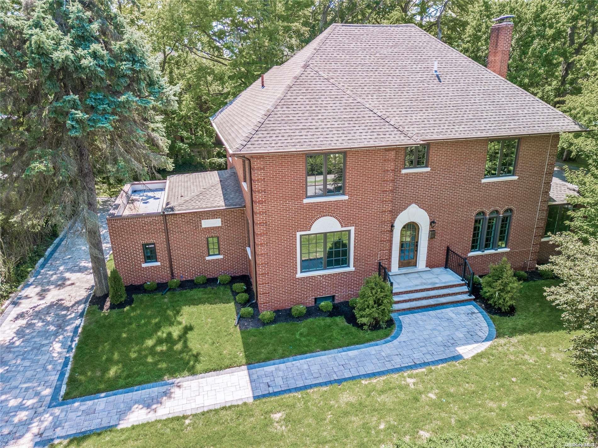a aerial view of a house with a yard plants and large tree