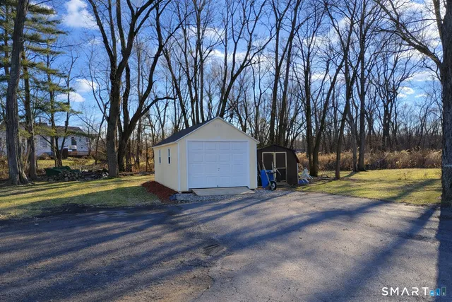 a view of a house with a yard and large trees